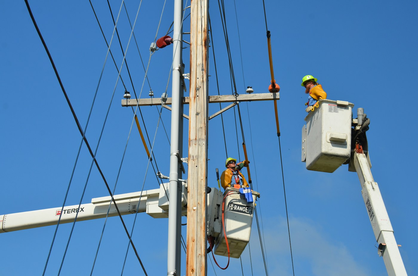 Bryan Municipal Utilities lineworkers working together from bucket trucks